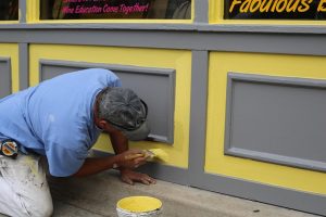 Ein Maler arbeitet im Außenbereich eines Gebäudes